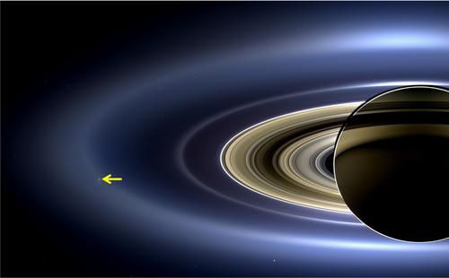 Image taken by NASA’s Cassini spacecraft showing Saturn’s rings in its full glory. The arrow is pointing at Enceladus orbiting Saturn embedded in the E ring which is created by ice grains emitted by Enceladus’ plume into space.